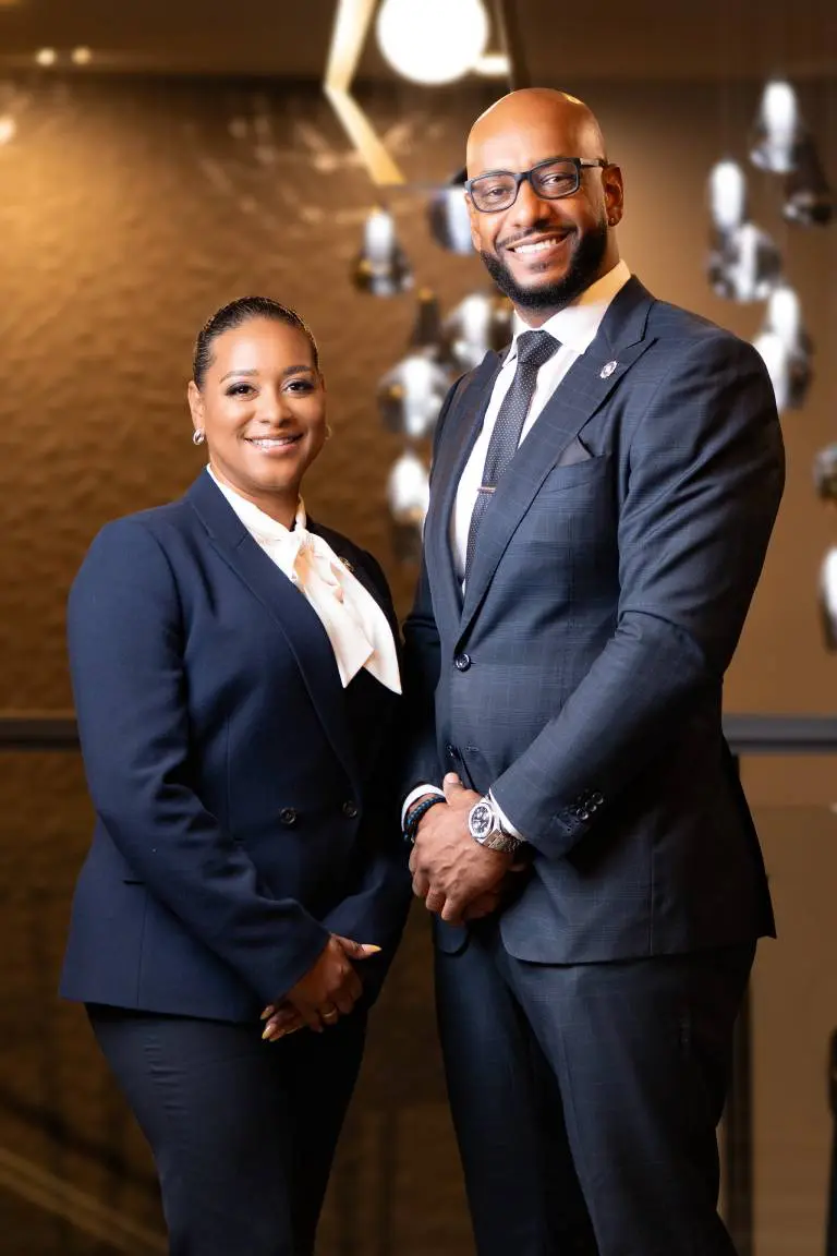 Couple image Two professionals posing in formal attire.
